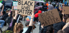 A photo of a Black Lives matter protest. Protestors are holding signs that says "Black Lives Matter."
